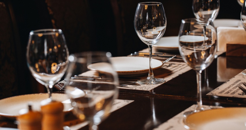 upscale dinner table with empty wine glasses and plates