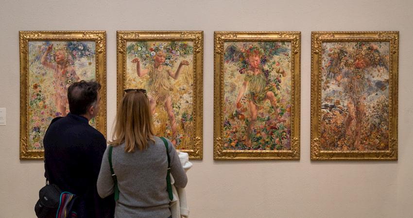 visitors admire a lineup of paintings at The Mennello Museum of American Art near Orlando Florida