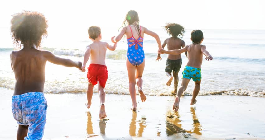 A group of kids running at the beach