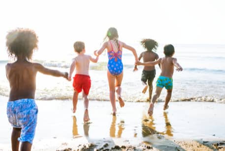 A group of kids running on a beach