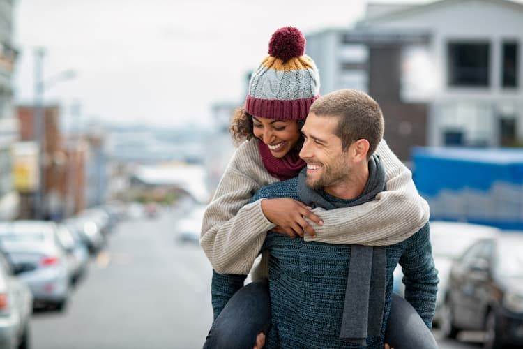 Woman riding piggyback on man