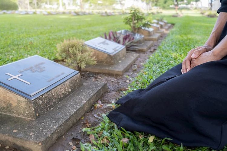 Woman kneeling at cemetery