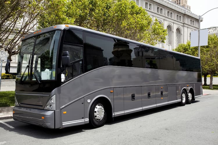 Gray tour bus outside building