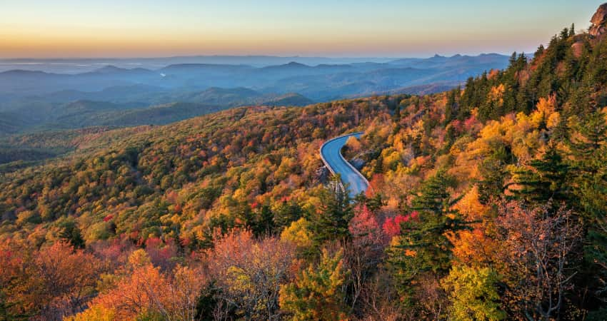 The Blue Ridge Parkway winds through autumn-colored trees and mountainsides