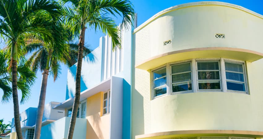 Art deco-style buildings in Miami, next to a palm tree