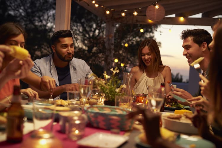 Friends have dinner outside at night