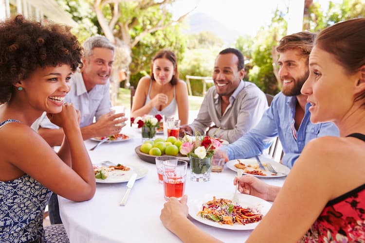 Large group laughing over food outside