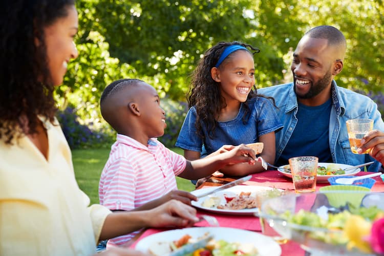 Parents and two kids eating outside