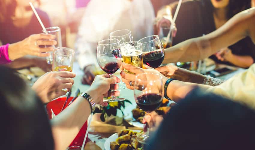 Friends toasting wine over food