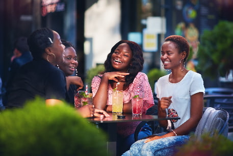 A group of friends enjoy colorful cocktails on a restaurant patio