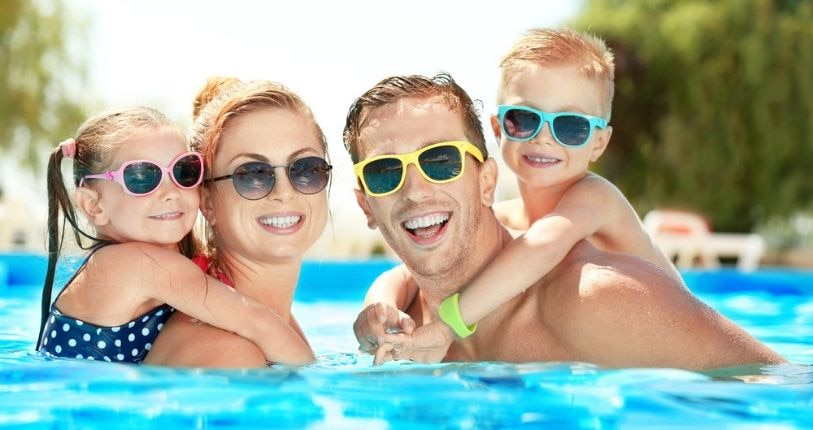 Family smiling together in pool