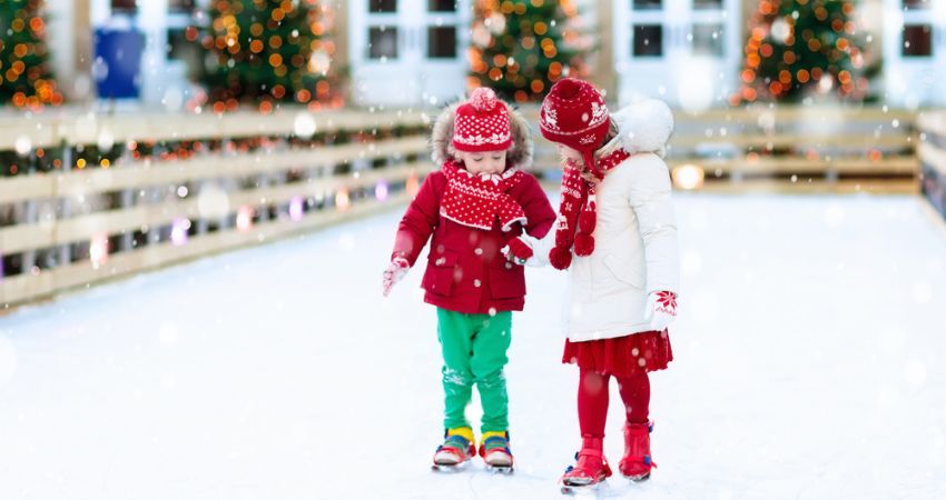 two young girls ice skating at christmas time