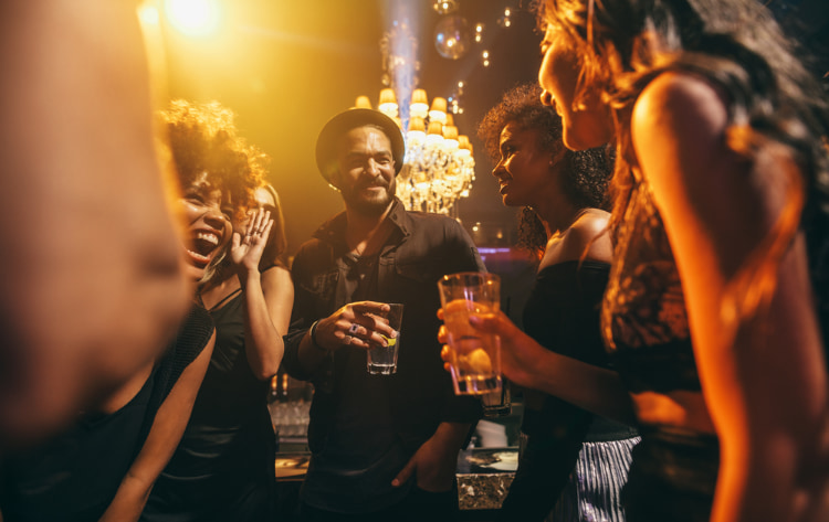 A group of people at a party, talking and having drinks.